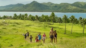 People walking trough Peaceful grasslands of Siargao